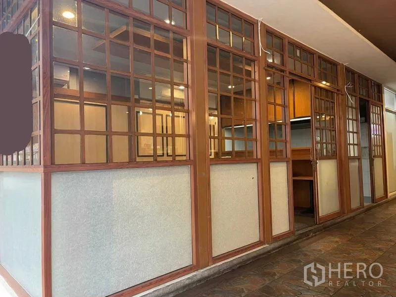 Retail Space for rent in Watthana, Bangkok - Wood-and-glass lattice storefront of a compact retail unit along a covered walkway in Phrom Phong, Watthana.