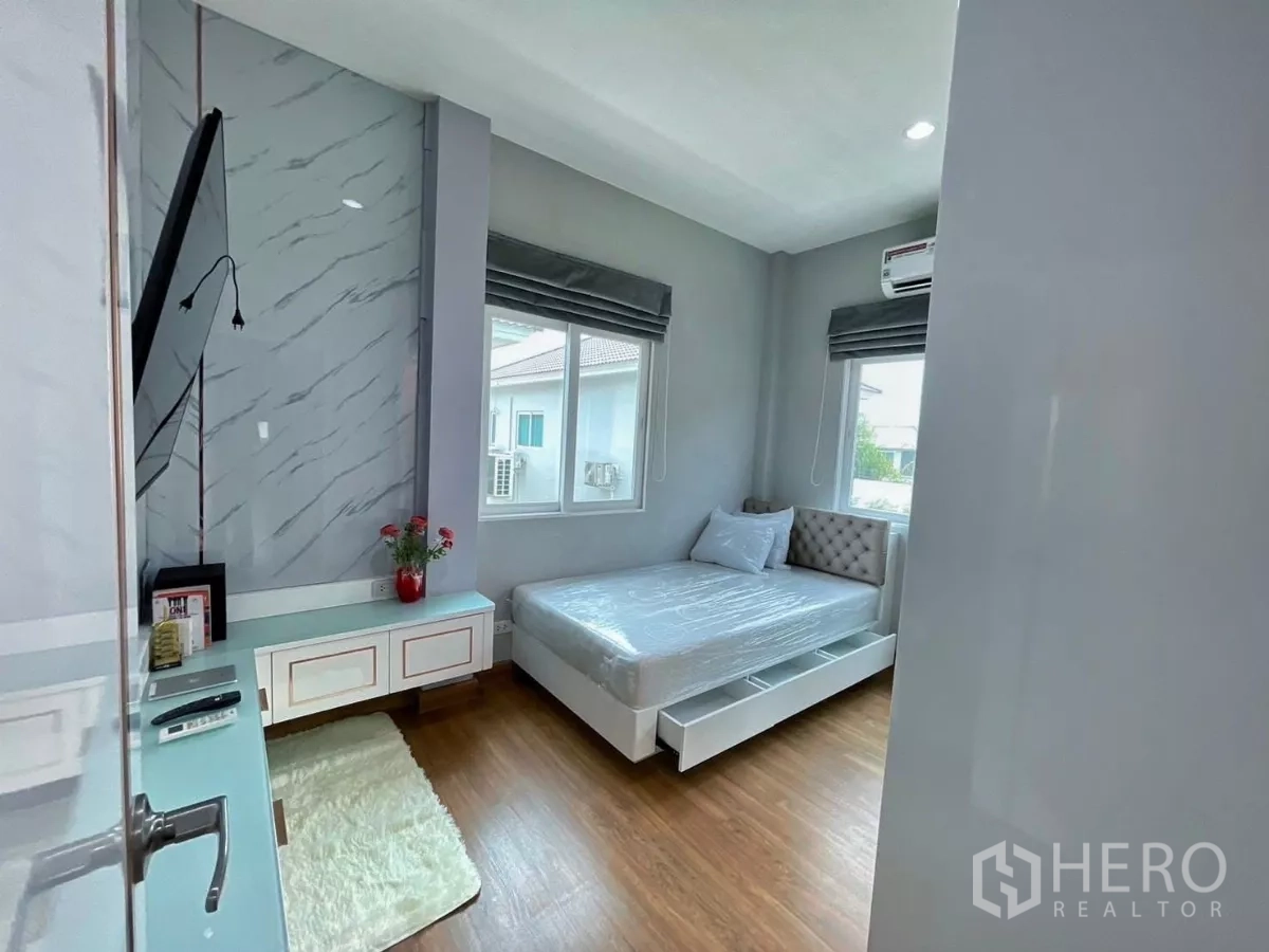 Detached House for rent in Bang Khen, Bangkok - Furnished secondary bedroom with windows, built‑in cabinet and wood floors.