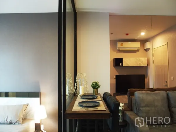 คอนโด ให้เช่าในHuai Khwang, Bangkok - โซนพักผ่อนแบบเปิดโล่ง โต๊ะทานอาหารสูง ทีวี และเครื่องปรับอากาศ ข้างฉากกั้นห้องนอน