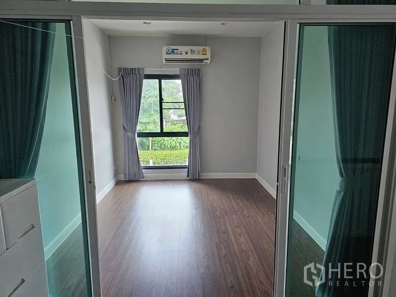 Detached House for rent or sale in Lam Luk Ka, Pathum Thani - Upstairs room with wood flooring, air conditioner and sliding glass partitions
