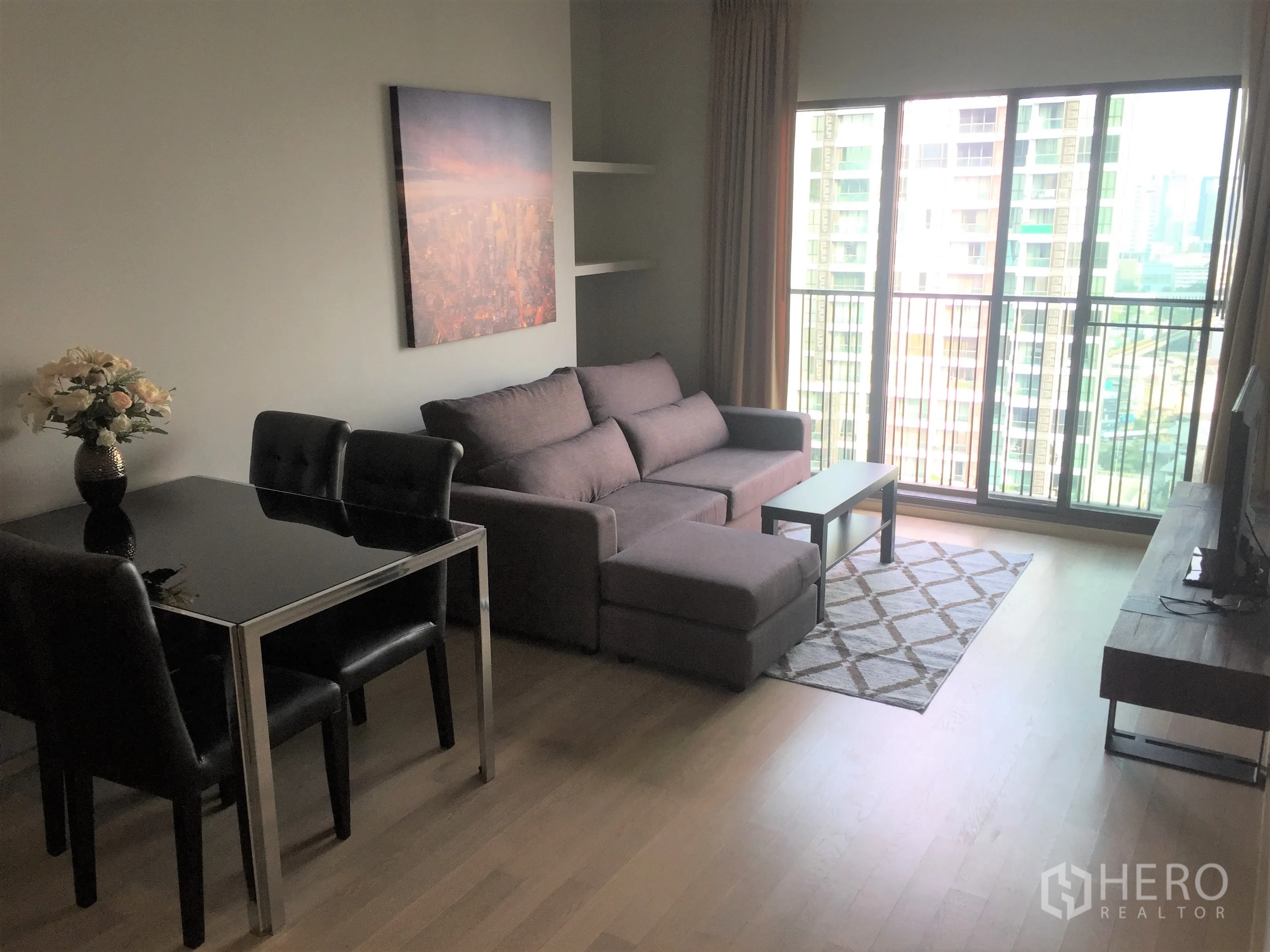 公寓 出租在Bangkok - 采光充足的客厅，落地窗与阳台，城市景观、地毯与电视柜