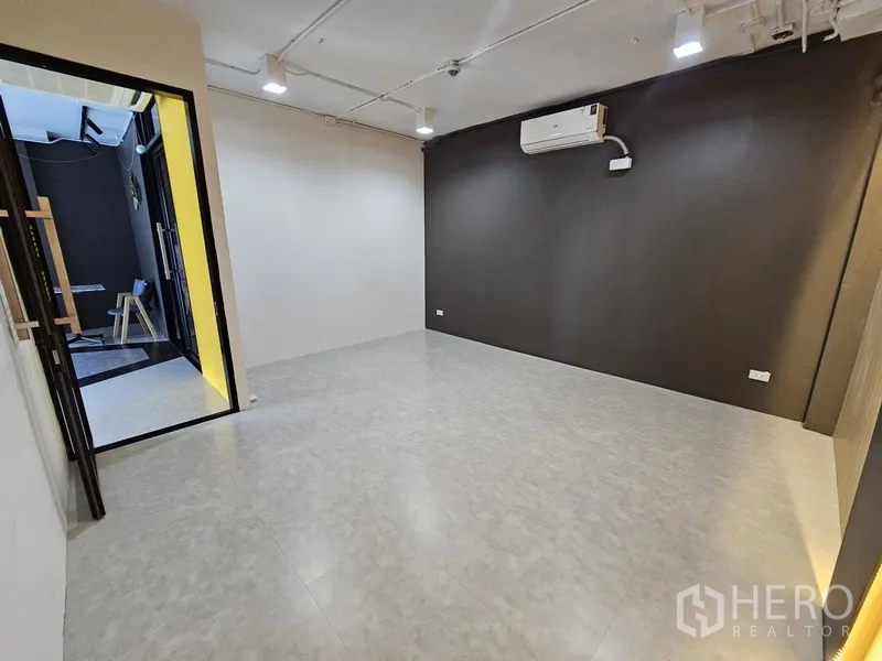 Retail Space for rent - Private room with air conditioner, contrasting white and charcoal walls, and tiled flooring.