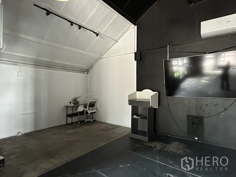 Retail Space for rent in Phra Khanong, Bangkok - Open-plan area with high white ceiling, desk, wall-mounted screen and air conditioner.