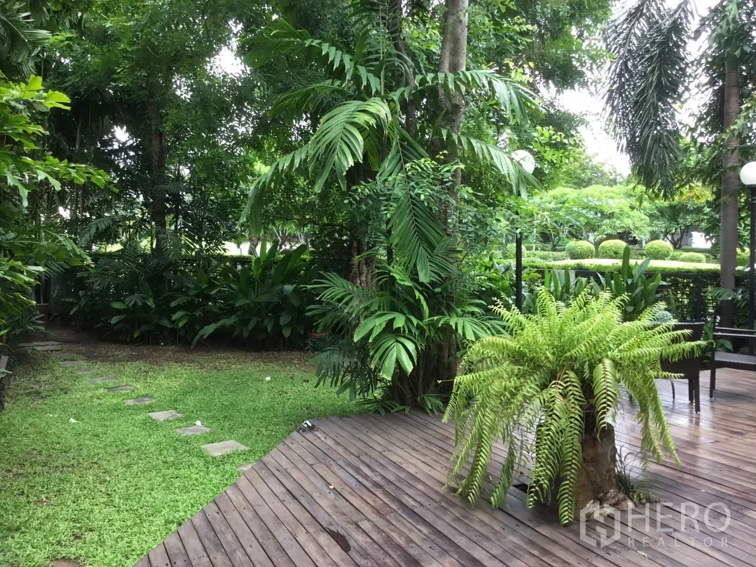 独栋房屋 for sale in Suan Luang, Bangkok - 木平台连接草坪与石板小径，绿意环绕。