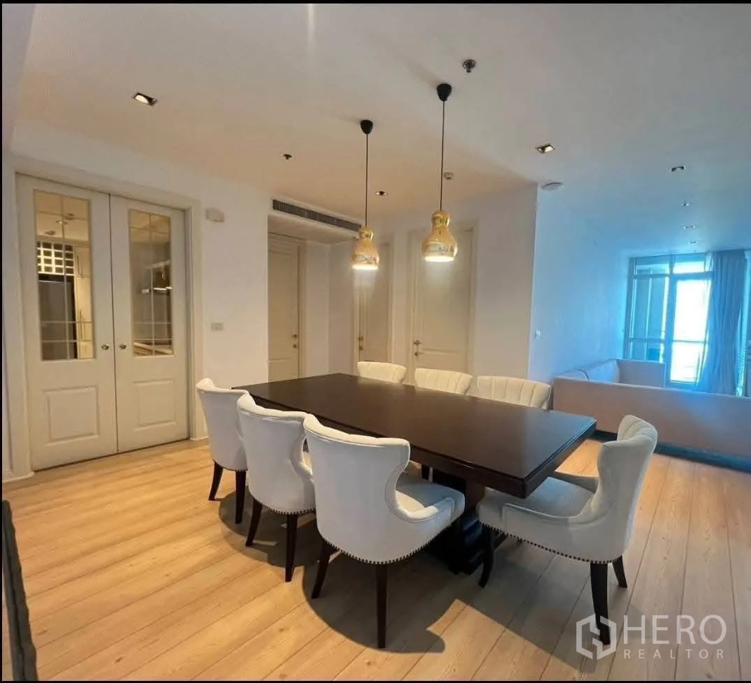 公寓 for rent in Pathum Wan, Bangkok - 餐区设八人餐桌与吊灯，紧邻客厅空间。
