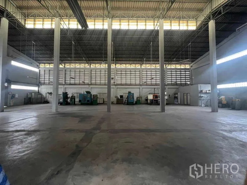 货栈 出租在Lam Luk Ka, Pathum Thani - 白色仓库外立面，多扇卷闸门和开阔前院