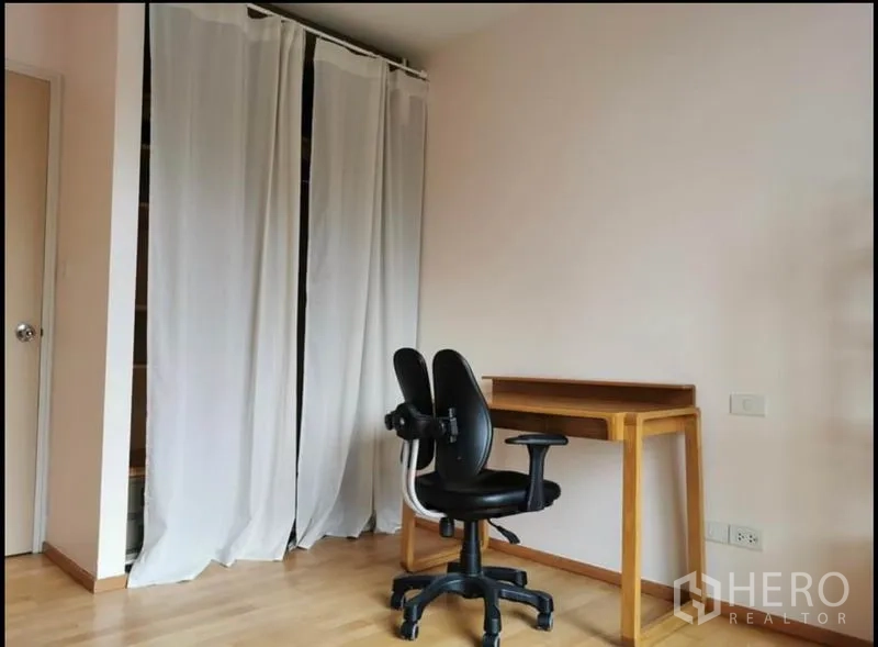 Condominium for rent in Khlong Toei, Bangkok - Second bedroom or study with desk, office chair, and curtain wardrobe.