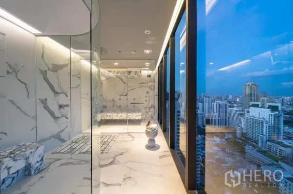 Condominium for rent in Watthana, Bangkok - Rooftop marble steam room with glass walls and panoramic Bangkok skyline at dusk.