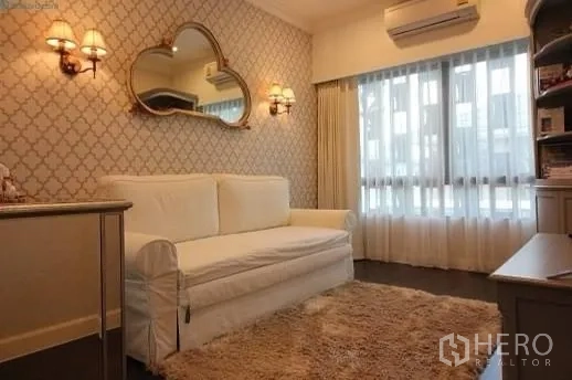 Detached House for rent or sale in Prawet, Bangkok - Elegant multipurpose room with white sofa, patterned wallpaper, wall sconces, and a plush rug.