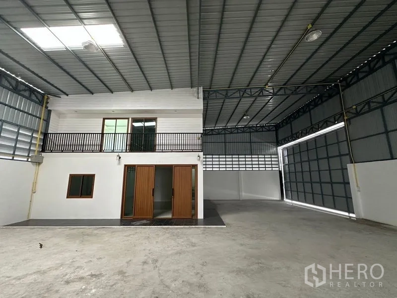 Warehouse for rent in Lam Luk Ka, Pathum Thani - Internal two-storey office suite with balcony and double wooden sliding entrance doors.