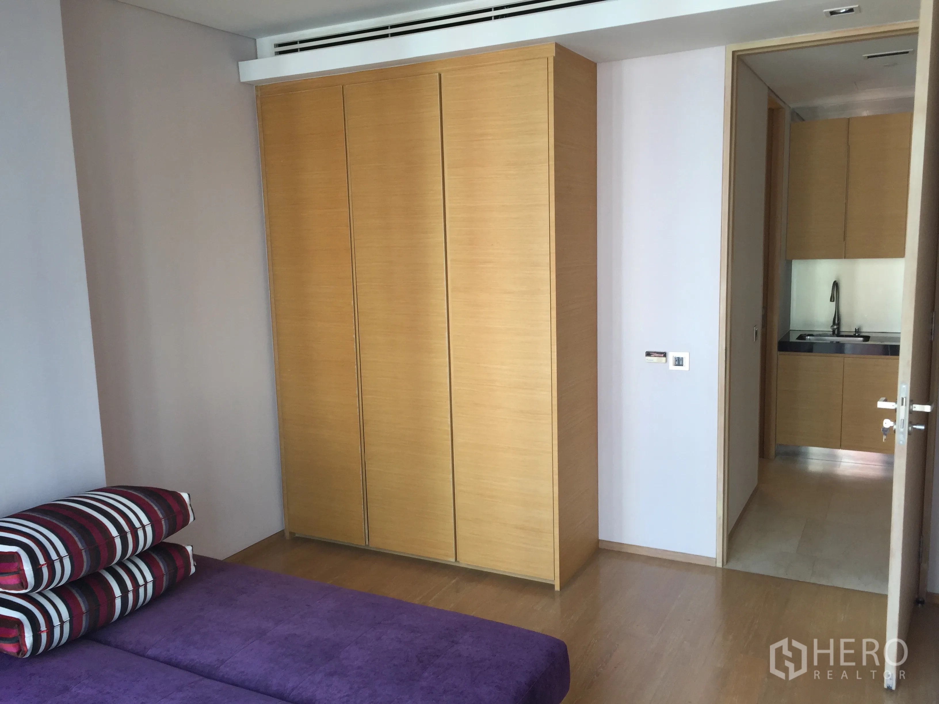 Condominium for rent or sale in Bang Rak, Bangkok - Second bedroom with full-height wardrobe and purple daybed near the pantry.
