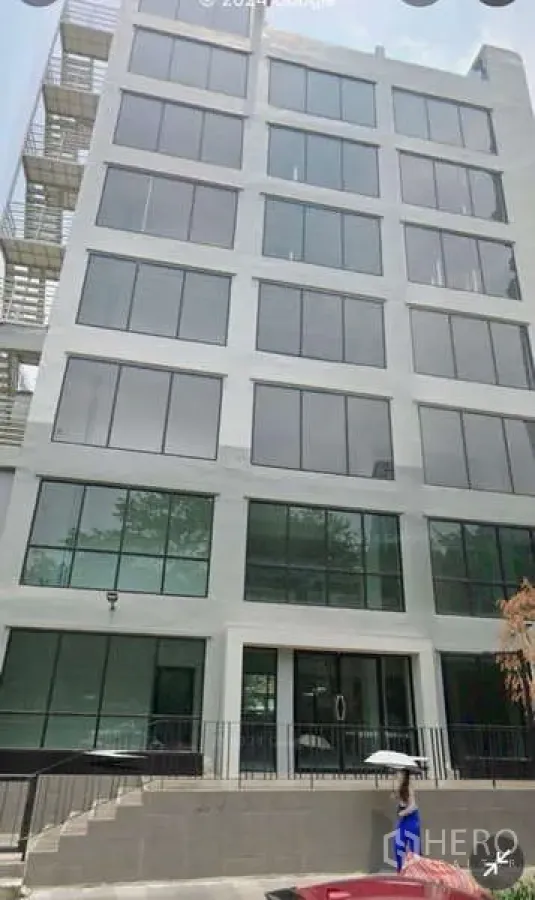Office Space for rent in Bang Rak, Bangkok - Refurbished seven-storey standalone office facade with large grid windows.