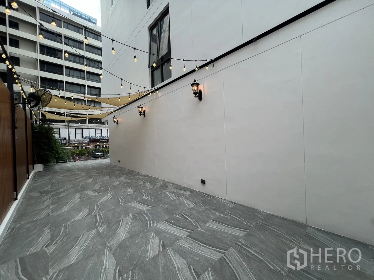 零售空间 出租 - 户外座席区配有串灯与风扇，可望向街景。