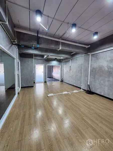 办公空间 出租或出售在Bueng Kum, Bangkok - 工业风办公室，木地板、清水混凝土墙、吊灯与滑动玻璃隔断。