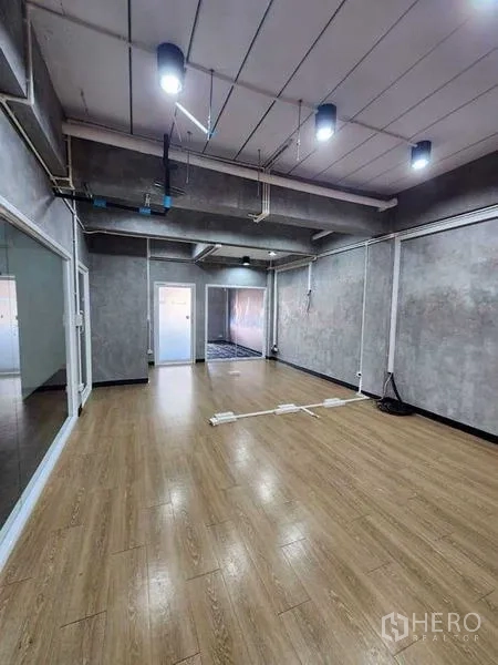 办公空间 出租或出售在Bueng Kum, Bangkok - 工业风办公室，木地板、清水混凝土墙、吊灯与滑动玻璃隔断。