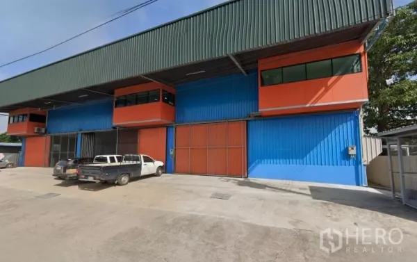 คลังสินค้า ให้เช่าในLat Krabang, Bangkok - ด้านหน้าโกดังโครงสร้างเหล็กสีสันสดใสที่ลาดกระบัง มีประตูสไลด์กว้างและลานจอดรถ