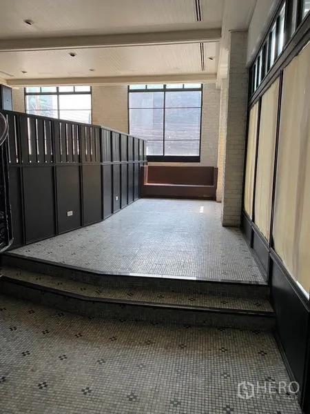 零售空间 出租在Khlong Toei, Bangkok - 入口层设台阶与马赛克地面，落地窗与靠窗座位区。