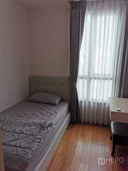 Condominium for rent or sale in Phra Khanong, Bangkok - Cozy second bedroom with single bed, desk and full-height curtained window.