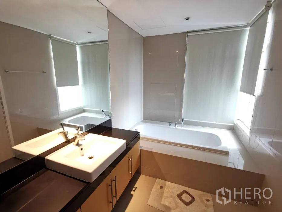 公寓 出租在Watthana, Bangkok - 当代风浴室，长台面洗手盆，靠窗内嵌浴缸与百叶帘。