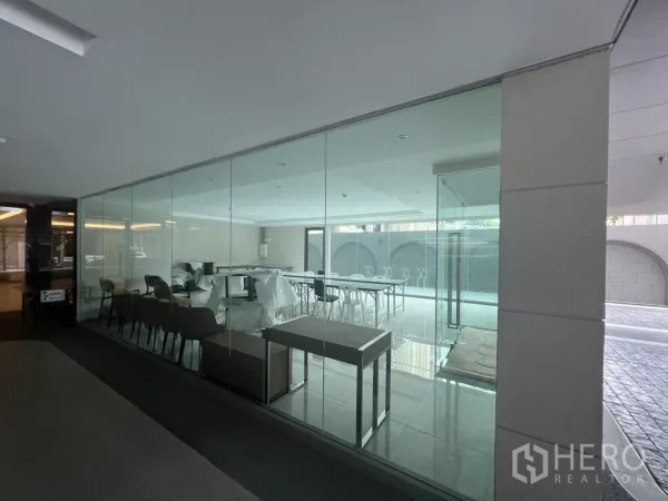 Retail Space for rent in Watthana, Bangkok - Glass-walled shop viewed from corridor showing seating area and open floor plan.
