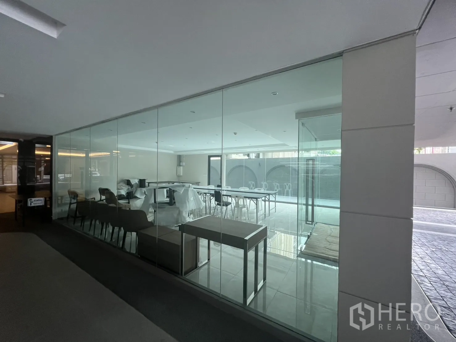 Retail Space for rent in Watthana, Bangkok - Glass-walled shop viewed from corridor showing seating area and open floor plan.