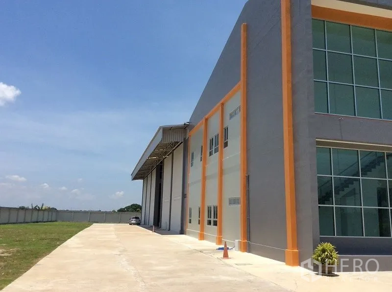 โรงงาน ขายในBang Sao Thong, Samut Prakan - ด้านข้างอาคารแสดงแนวโกดัง ทางขับคอนกรีต และสนามหญ้า.