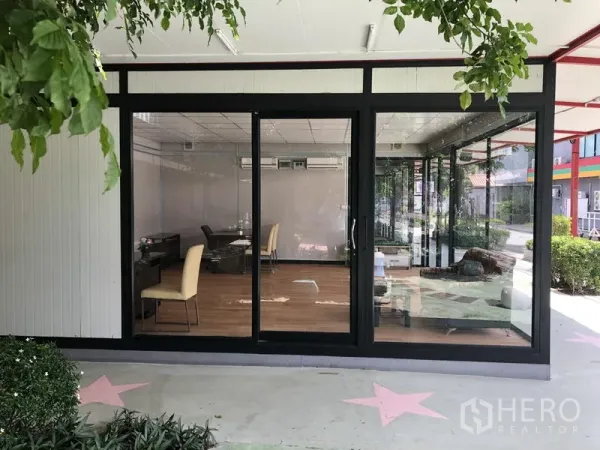 Office Space for rent in Wang Thonglang, Bangkok - Ground-floor office with full-height glass frontage, wood-look flooring, and desks in Wang Thonglang, Bangkok.