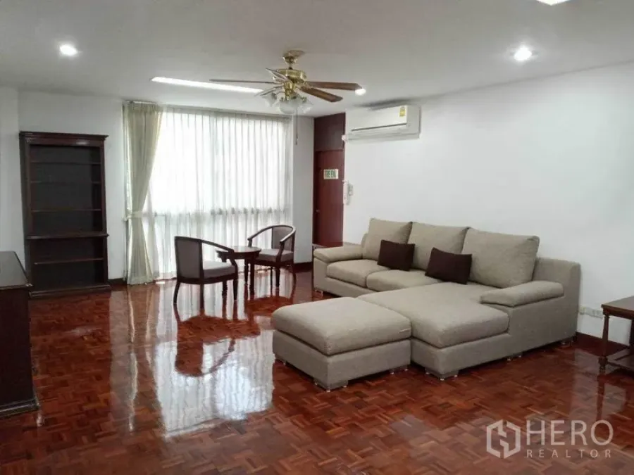 คอนโด ให้เช่าในWatthana, Bangkok - ห้องนั่งเล่นขนาดใหญ่ โซฟา L-shape พัดลมเพดาน และพื้นไม้เงา