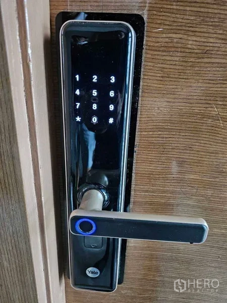 Condominium for rent in Bang Rak, Bangkok - Digital keypad smart door lock installed on a wooden entrance door.