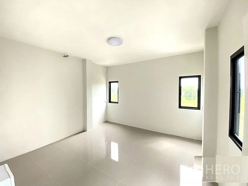 Factory for rent in Bang Bua Thong, Nonthaburi - Second bedroom with corner windows bringing natural light.