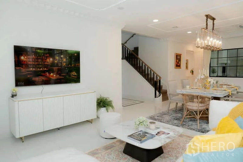 Detached House for rent or sale in Saphan Sung, Bangkok - Living area view toward dining room and staircase with a wall-mounted TV.