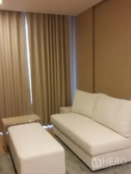 คอนโด ให้เช่าในWatthana, Bangkok - มุมนั่งเล่นโซฟาสีขาว ออตโตมัน และผ้าม่านทึบแสง