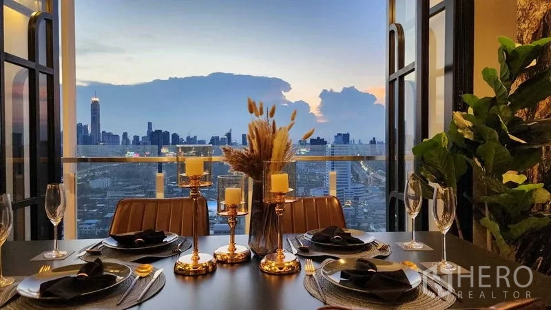 Condominium for sale - Dining table set against a sunset balcony skyline view near MRT Phra Ram 9.
