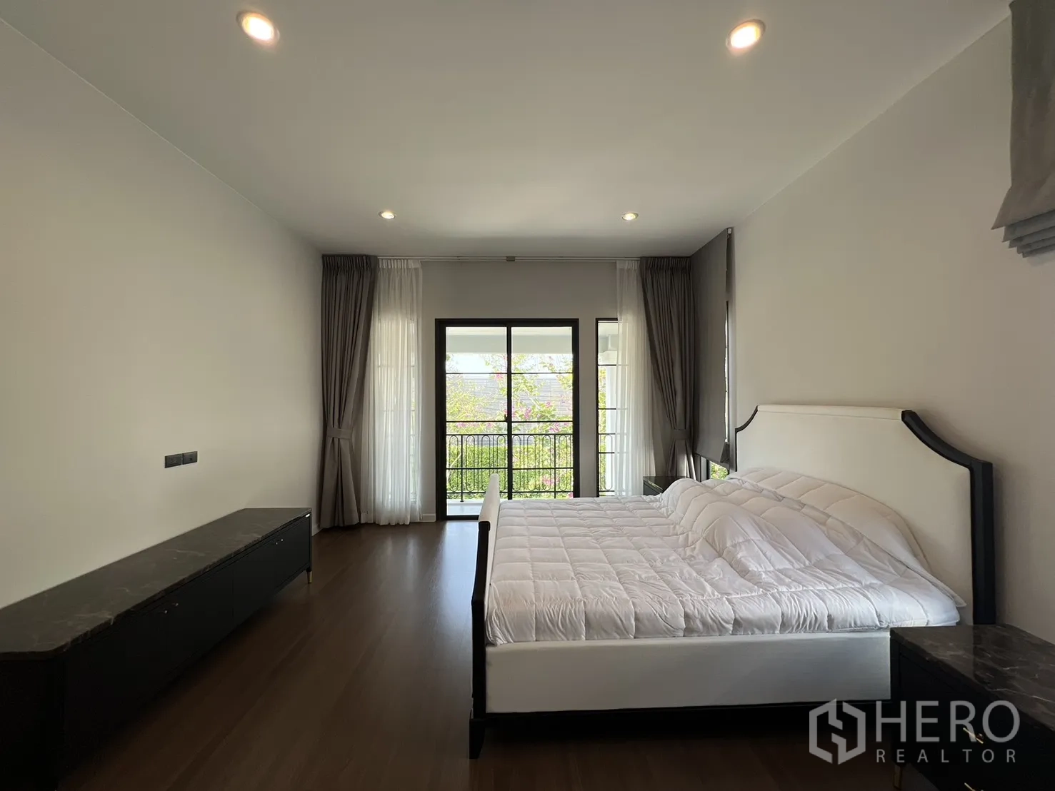 Detached House for rent in Bang Phli, Samut Prakan - Bedroom with sliding glass doors to a balcony and layered curtains.