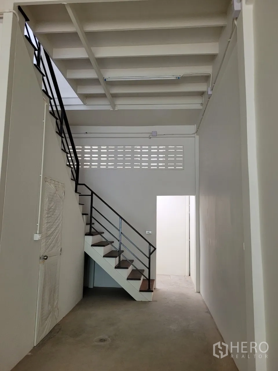 Shophouse for rent in Khlong Toei, Bangkok - Rear section with a metal handrail staircase and doorway providing access to the back area.
