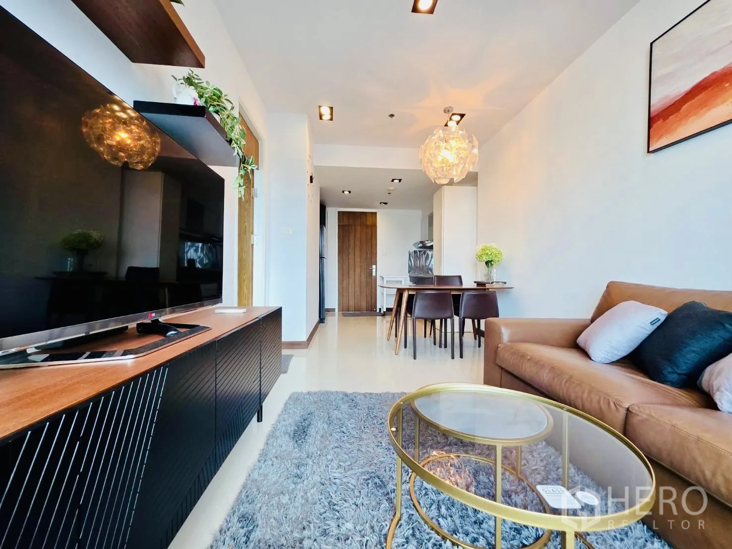 คอนโด for rent in Huai Khwang, Bangkok - ห้องนั่งเล่นโอเพ่นพลัน ตู้วางทีวีและชั้นลอยหันหน้าเข้าหาโซฟาหนังและชุดทานอาหาร