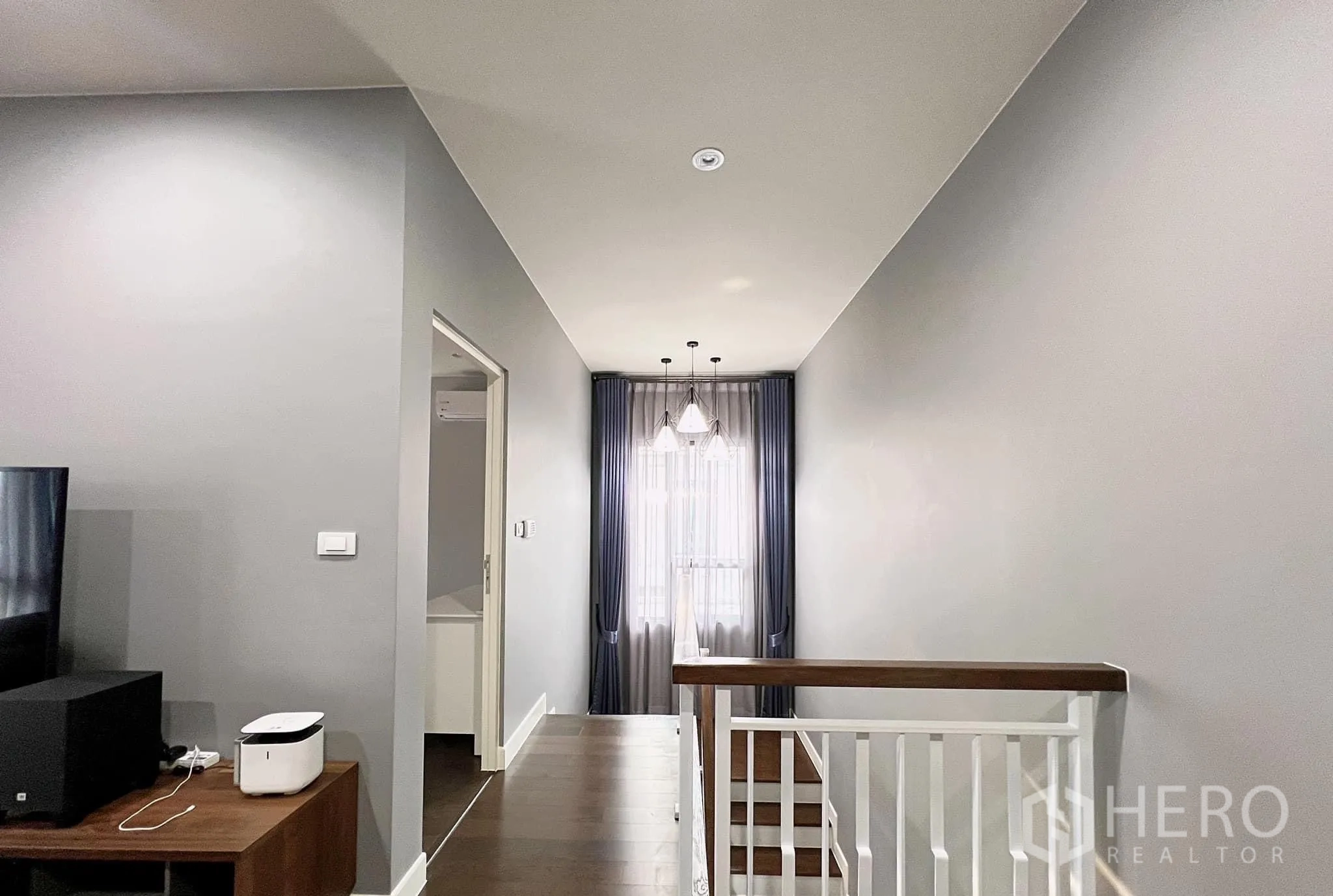 Detached House for rent or sale in Lam Luk Ka, Pathum Thani - Upper hallway with pendant lights and curtains at the landing window.
