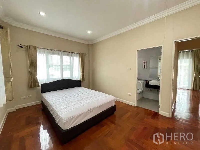 独立式住宅 出租在Mueang Nonthaburi, Nonthaburi - 次卧带套内卫浴，木地板与明亮窗户。