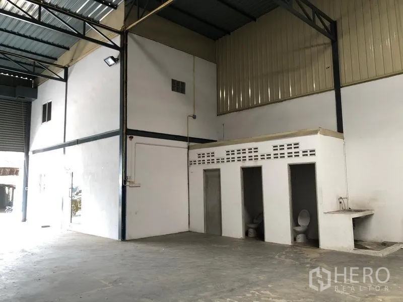 货栈 出租在Pak Kret, Nonthaburi - 仓库一角，内置卫生间、洗手槽与钢梁屋顶。