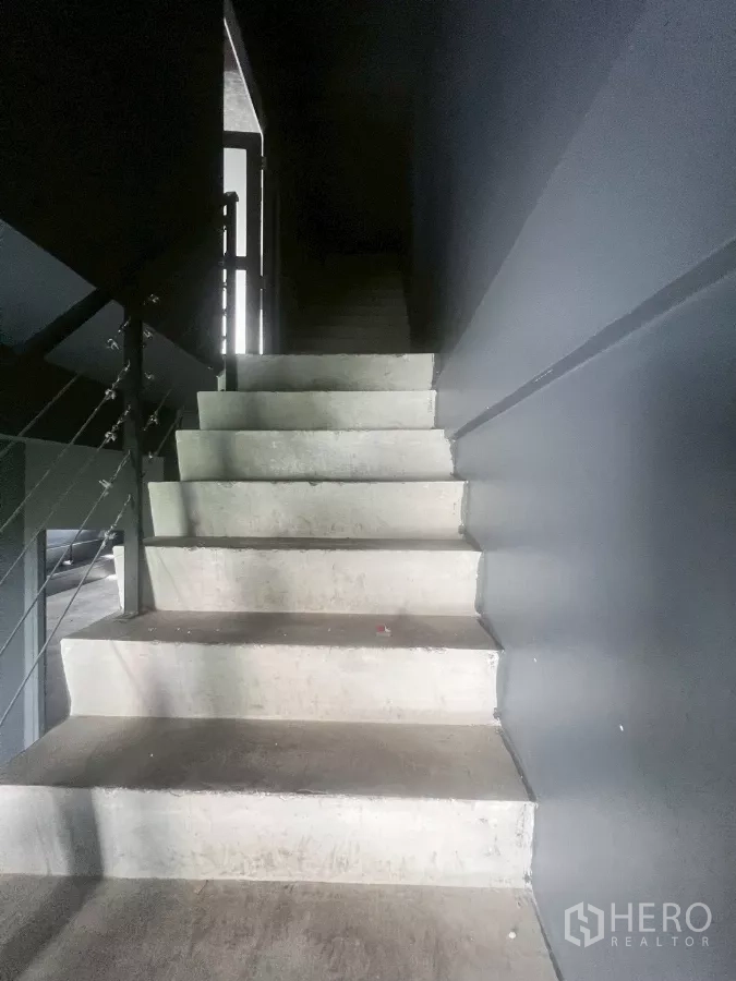 店屋 出租在Watthana, Bangkok - 室内混凝土楼梯配金属扶手。