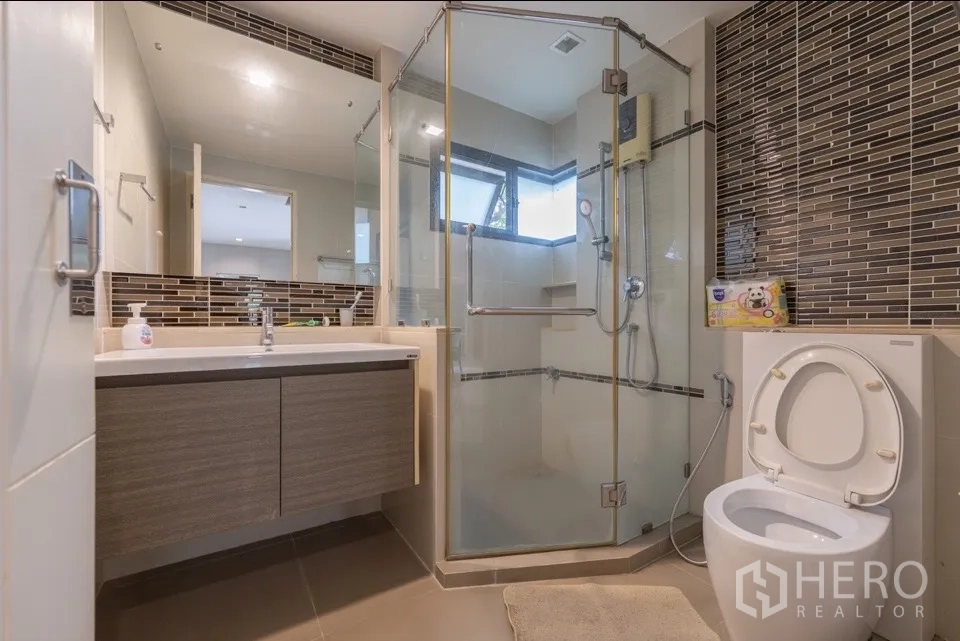独栋房屋 for rent or sale in Bang Kapi, Bangkok - 现代浴室，玻璃淋浴间、洗手台与坐便器。