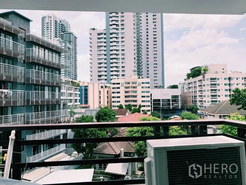 公寓 出租在Watthana, Bangkok - 阳台远眺素坤逸城市景观与绿意，前方空调外机。