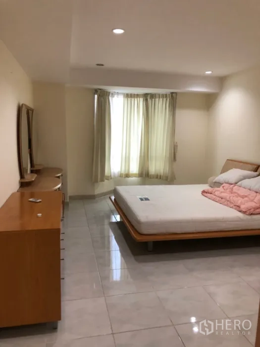 Condominium for rent in Watthana, Bangkok - Repeat view: large bedroom with bed and dresser by the window.