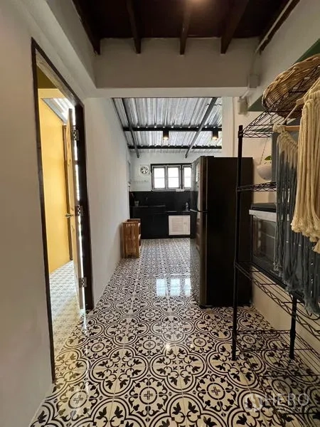 Townhouse for rent in Ratchathewi, Bangkok - Pantry corridor with open shelving and refrigerator leading into the tiled kitchen.