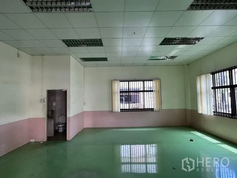 Warehouse for rent in Bang Sao Thong, Samut Prakan - Internal office room with windows, tiled restroom and drop ceiling inside the warehouse.