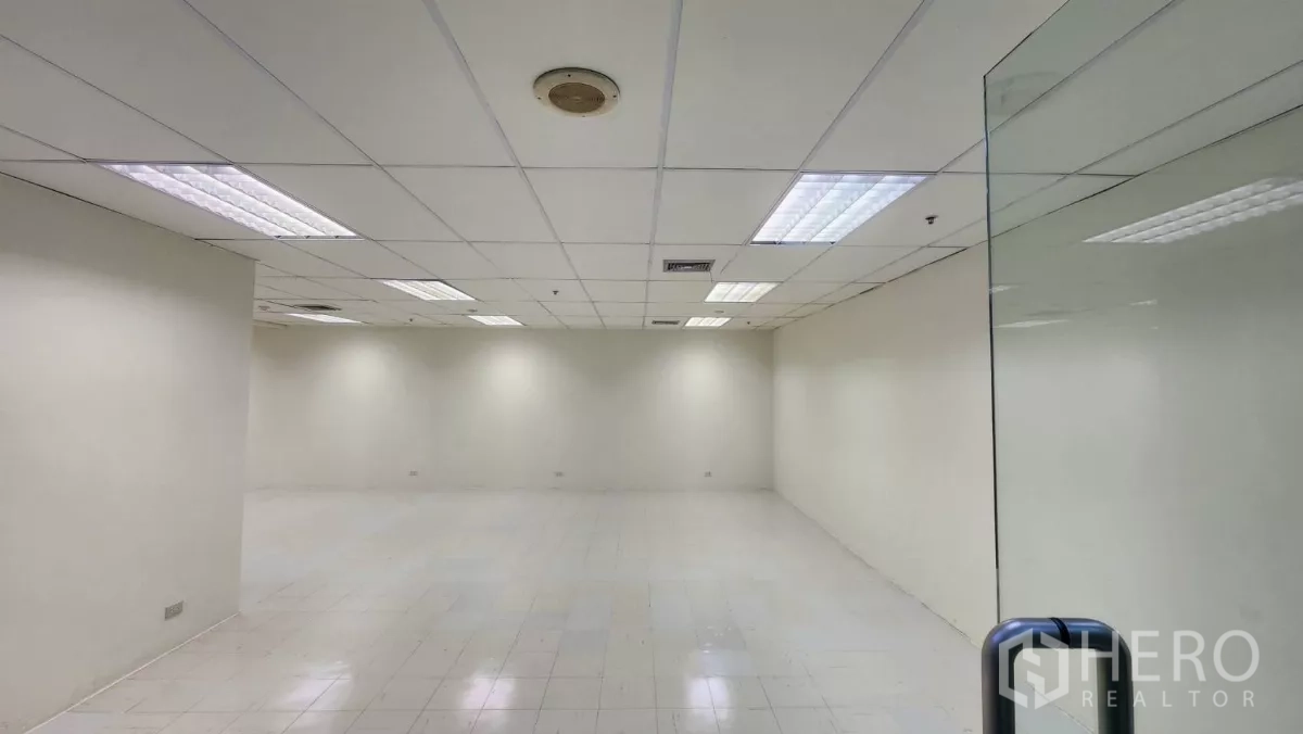 办公空间 出租在Watthana, Bangkok - 无窗办公区，吊顶栅格、荧光灯与空调出风口，白色地砖