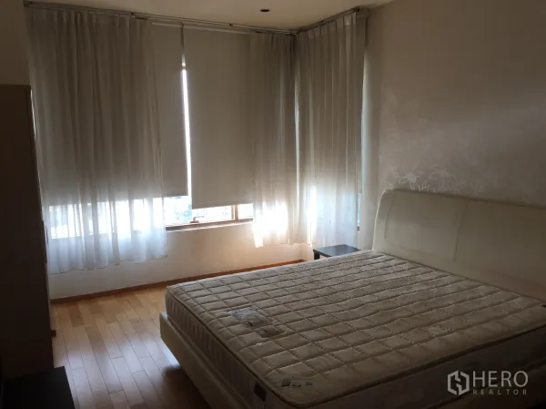 公寓 出租或出售在Khlong Toei, Bangkok - 主卧配大床，木地板，转角窗搭配遮光帘与纱帘。