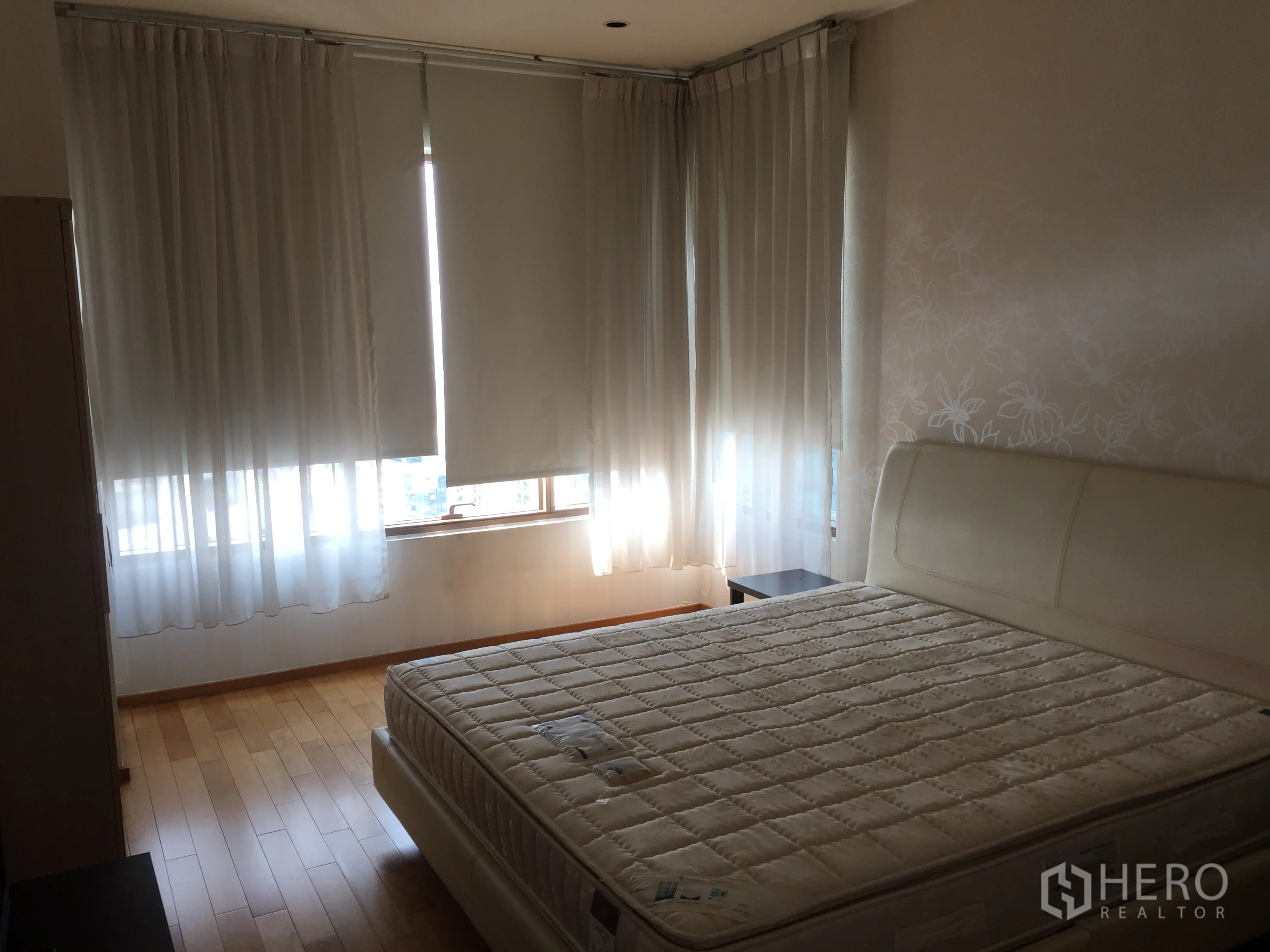 公寓 出租或出售在Khlong Toei, Bangkok - 主卧配大床，木地板，转角窗搭配遮光帘与纱帘。
