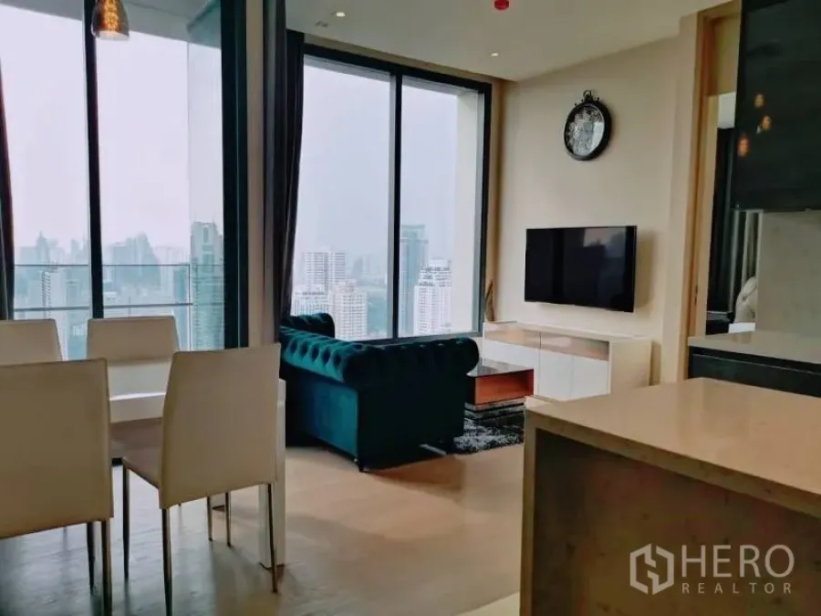 Condominium for rent or sale in Watthana, Bangkok - Open-plan living, dining and kitchen with floor-to-ceiling windows and Bangkok skyline view.