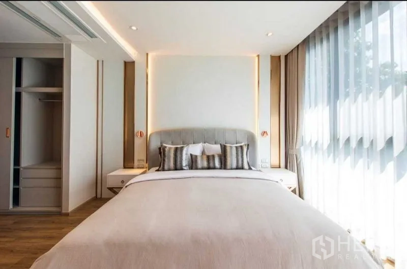 公寓 出租在Bang Na, Bangkok - 明亮卧室，软包床头、床头柜与整面落地窗。